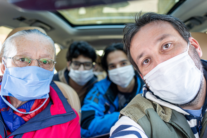 People in a car wearing facemasks